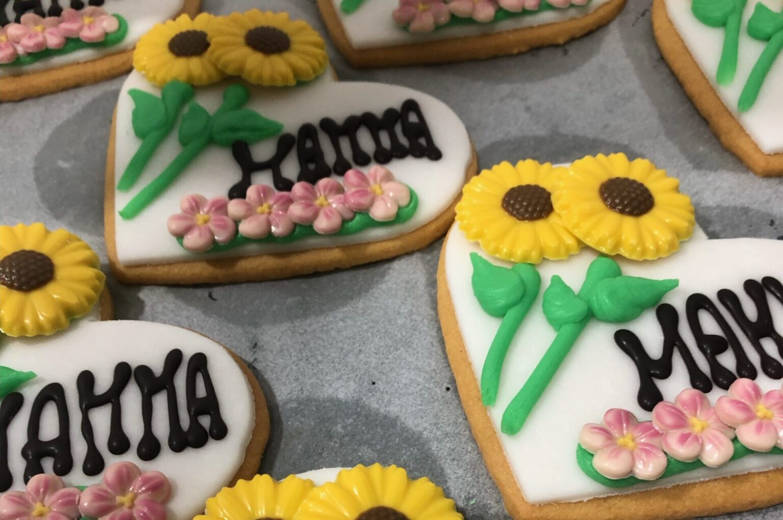 biscotti a forma di cuore con la scritta mamma e decorazioni floreali